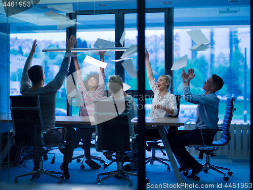 Image of multiethnic Group of young business people throwing documents