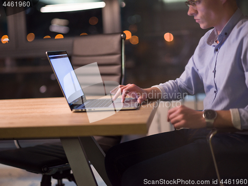 Image of man working on laptop in dark office