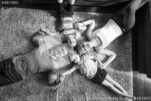 Image of happy family lying on the floor