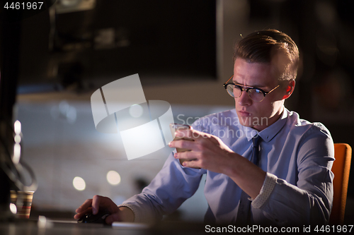 Image of man using mobile phone in dark office