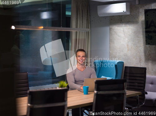 Image of man working on laptop in dark office