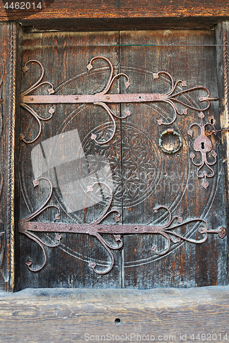 Image of old wooden door with carved metal handle