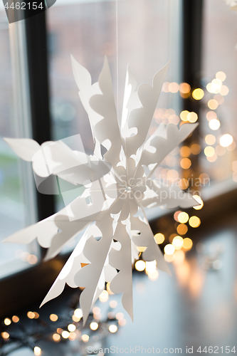 Image of paper snowflake decoration hanging on window