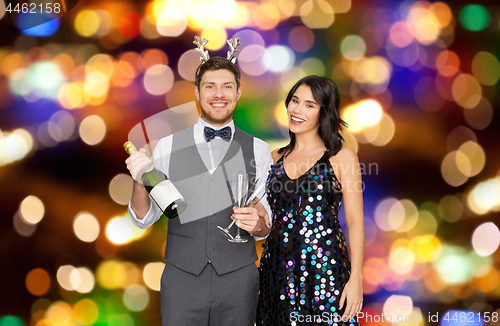 Image of couple with champagne bottle at christmas party