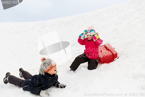 Image of happy little kids with sled down hill in winter