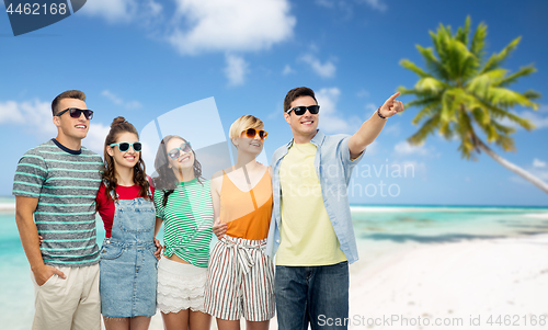 Image of friends in sunglasses over tropical beach