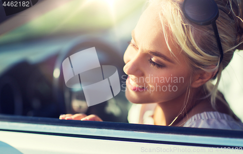 Image of happy teenage girl or young woman in car