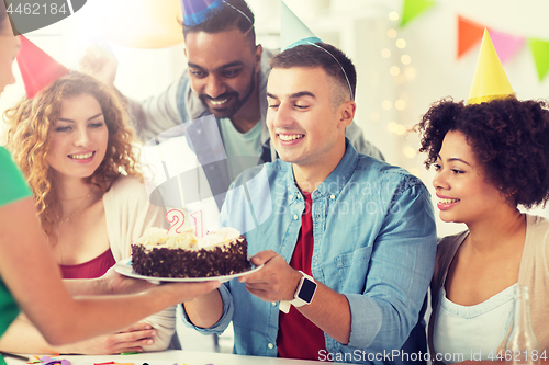 Image of team greeting colleague at office birthday party