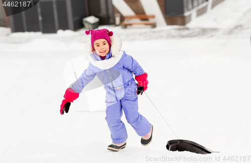 Image of little girl with sleds on snow hill in winter