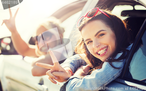 Image of happy teenage girls or women in car at seaside