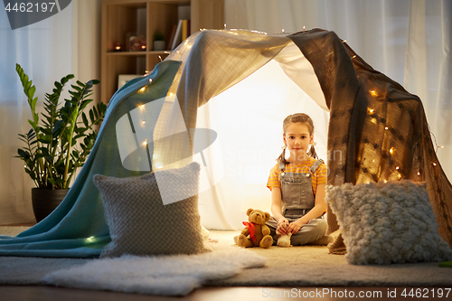 Image of little girl with toys in kids tent at home