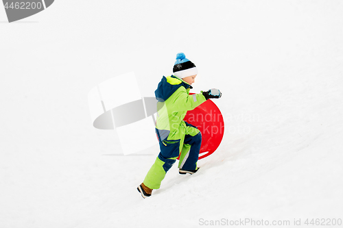 Image of happy boy with snow saucer sled in winter