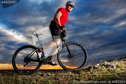 Image of Man in helmet and glasses stay on the bicycle