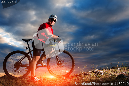 Image of Man in helmet and glasses stay on the bicycle