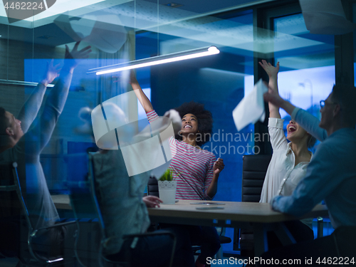 Image of multiethnic Group of young business people throwing documents