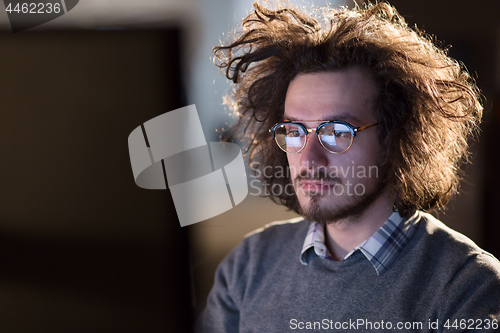 Image of man working on computer in dark office