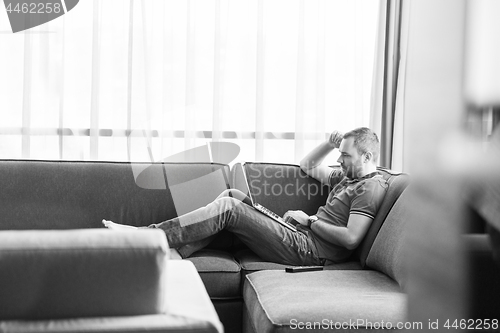 Image of Man using laptop in living room