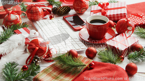 Image of Christmas symbols around devices and hot beverage