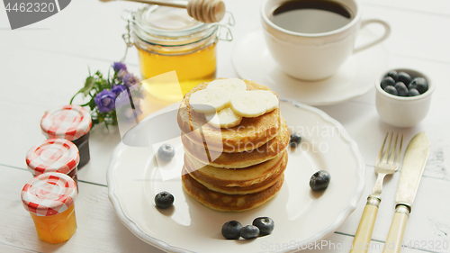 Image of Pancakes with slices of banana and berries