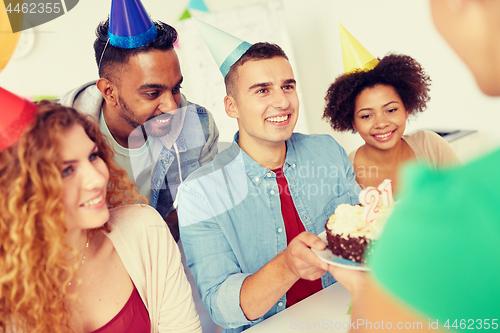 Image of team greeting colleague at office birthday party