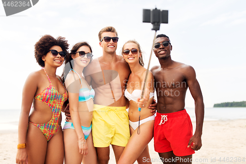 Image of happy friends taking selfie on summer beach