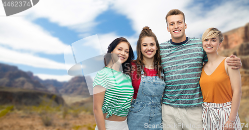 Image of happy friends hugging over grand canyon