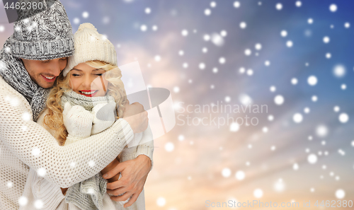 Image of smiling couple in sweaters over snow background