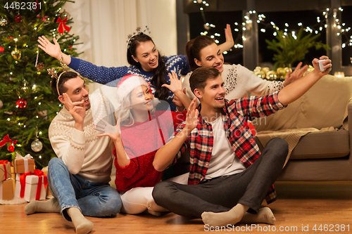 Image of friends celebrating christmas and taking selfie