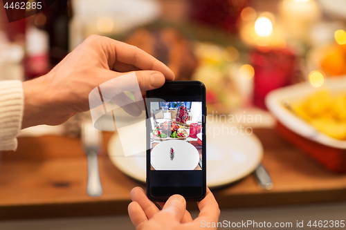 Image of hands photographing food at christmas dinner