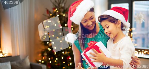 Image of happy mother and daughter with christmas gift