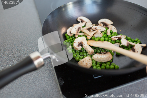 Image of close up of food in frypan on cooking panel