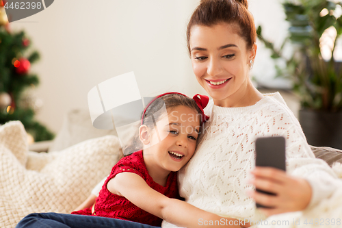 Image of family taking selfie by smartphone at home