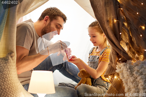 Image of family playing tea party in kids tent at home