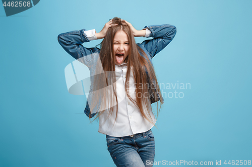 Image of The squint eyed teen girl with weird expression isolated on blue