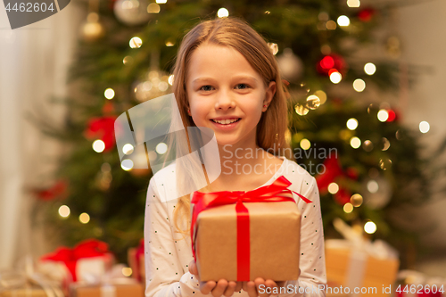 Image of smiling girl with christmas gift at home