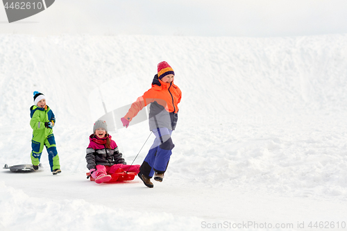 Image of happy kids with sled having fun outdoors in winter