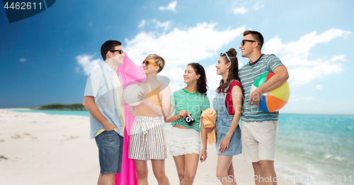 Image of happy friends with beach and summer accessories