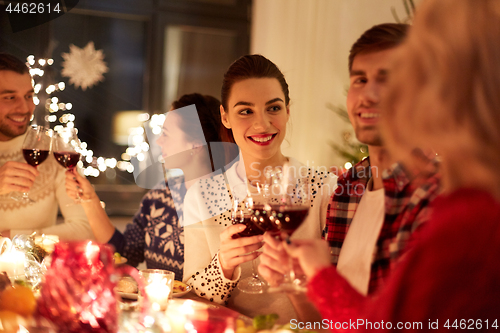 Image of happy friends celebrating christmas at home feast