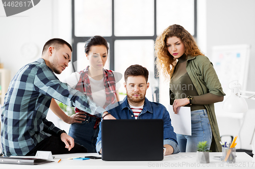 Image of creative team with laptop working at office