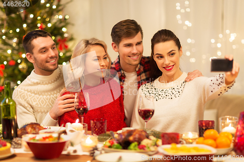 Image of friends taking selfie at christmas dinner