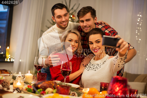 Image of friends taking selfie at christmas dinner