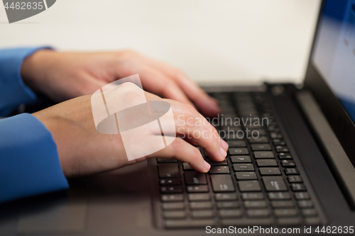 Image of close up of female hands with laptop typing