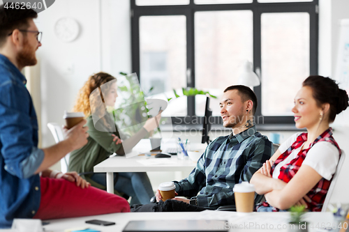 Image of creative team drinking coffee at office