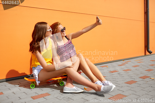 Image of teenage girls with skateboards taking selfie