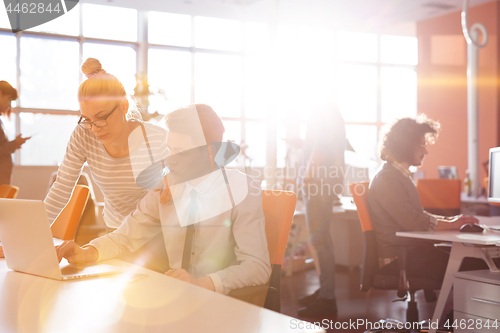 Image of Young businesswoman helping his colleague at the work