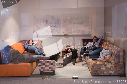 Image of software developers sleeping on sofa in creative startup office