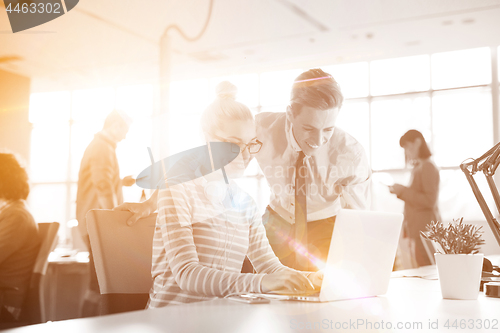 Image of Young businessman helping his colleague at the work