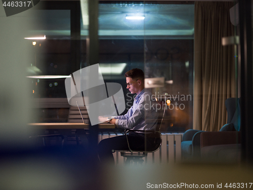 Image of man working on laptop in dark office