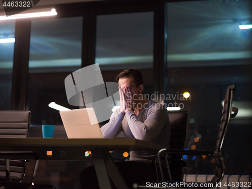 Image of man working on laptop in dark office