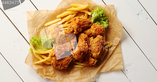 Image of Lettuce and French fries near chicken wings